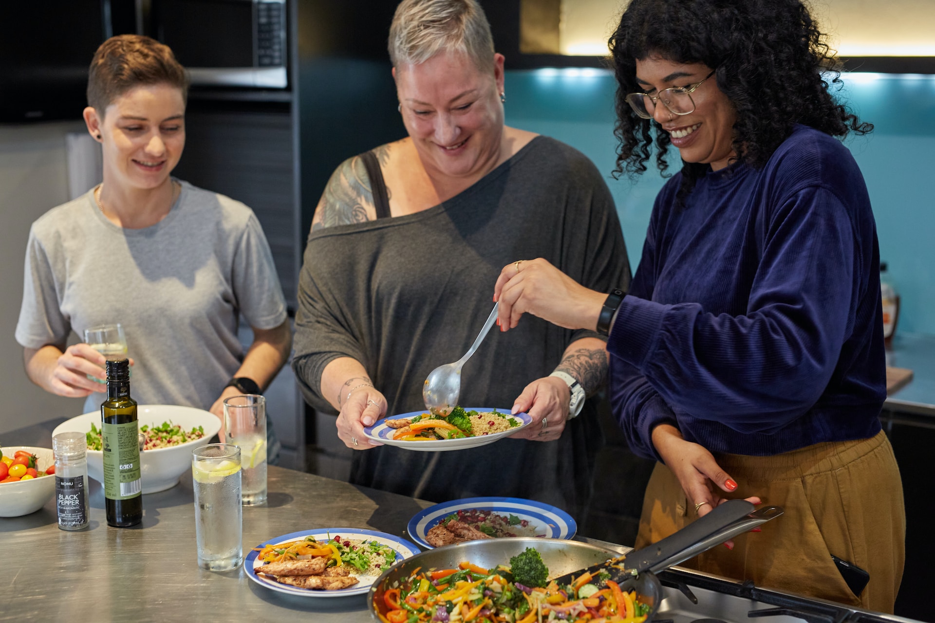 3 personnes qui cuisinent en souriant